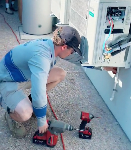 A Man Installing A New Air Conditioner  — Law Air Conditioning In Annandale, QLD