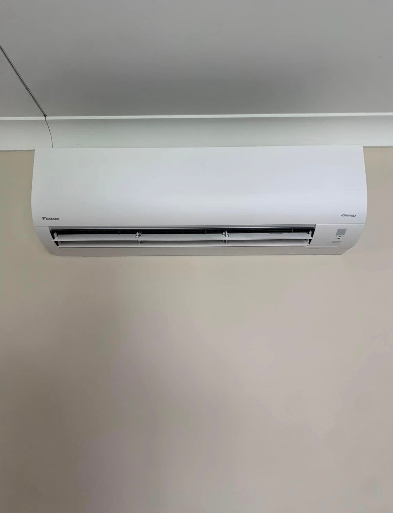 A White Air Conditioner Is Hanging From The Ceiling In A Room — Law Air Conditioning In Annandale, QLD