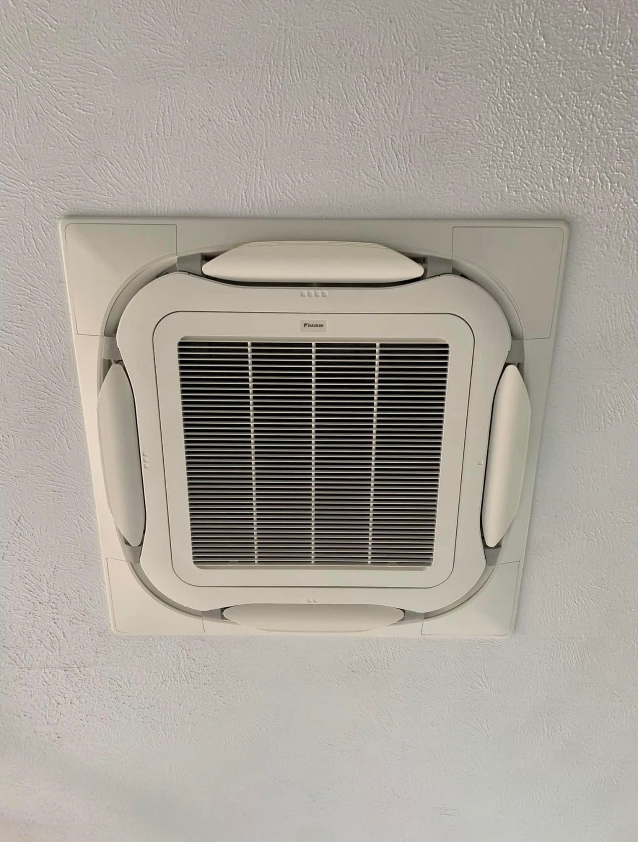 A Square Air Conditioner Is Hanging From The Ceiling In A Room — Law Air Conditioning In Annandale, QLD