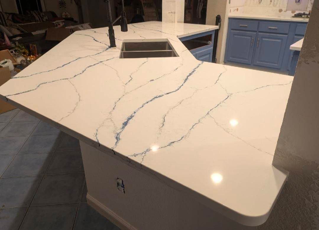 White quartz kitchen island countertop with gray veining and a built-in sink opening.