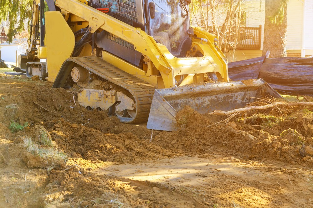 a yellow bulldozer is digging a hole in the dirt