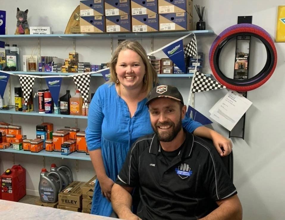 A Man And A Woman Are Posing For A Picture In A Store — Mundubbera Tyre Service In Mundubbera, QLD