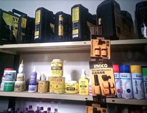 Estantes llenos de diversos suministros de ferretería, incluidas latas, botellas y pintura en aerosol.