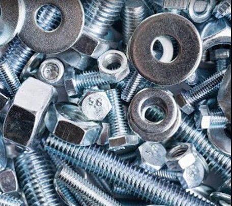 Pila de varias tuercas, tornillos y arandelas de metal.