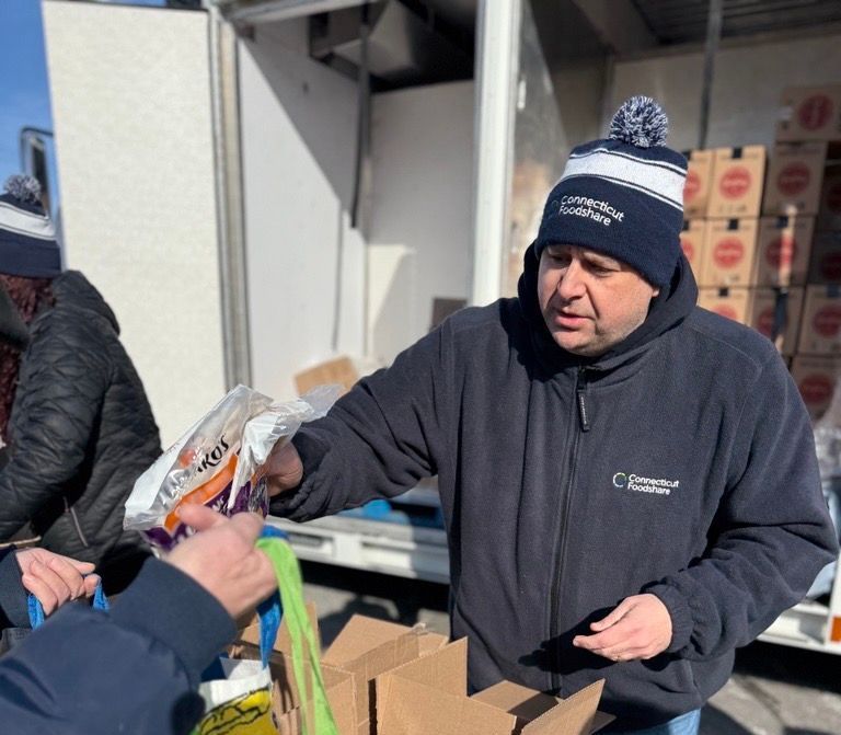 Jason Jakubowski, Connecticut Foodshare President and CEO, helping a neighbor at a mobile food pantry in New Britain, CT.