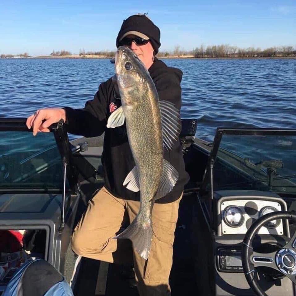 Andre Adams holding large fish in Lund boat on Lake Thompson
