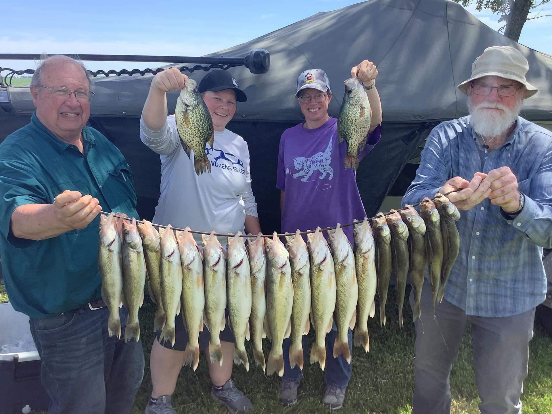 Man in boat on Lake Thompson, holding large walleye