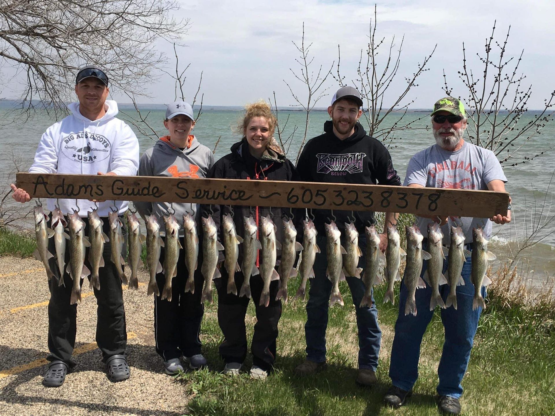 Group of 5 people holding day's catch of multiple species of fish