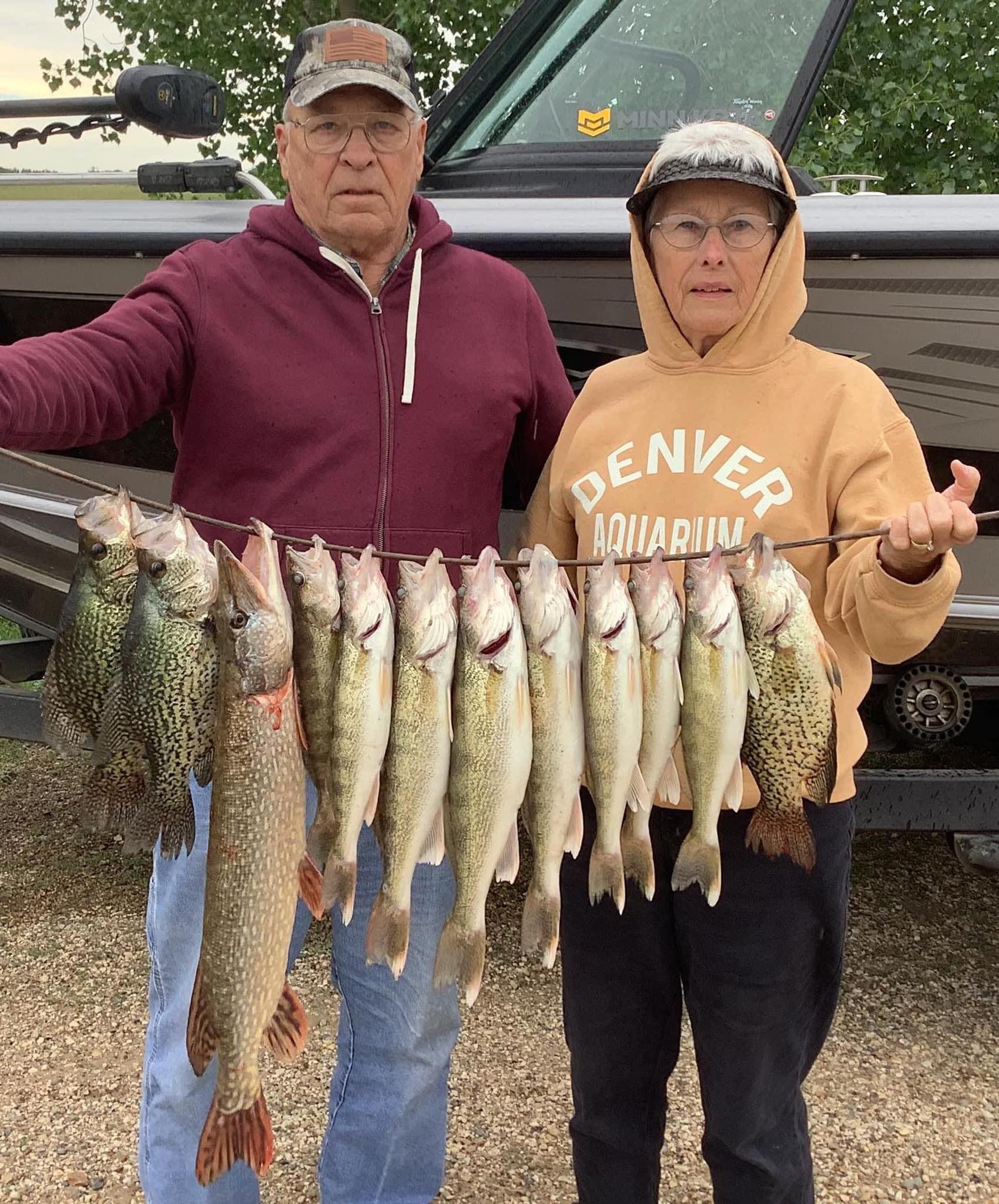 A couple holding up a stringer of fish