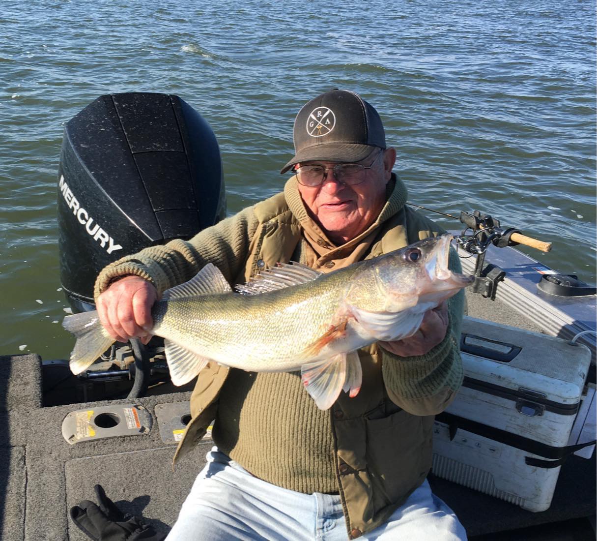 Gentleman holding large walleye on Lake Thompson in Lund boat