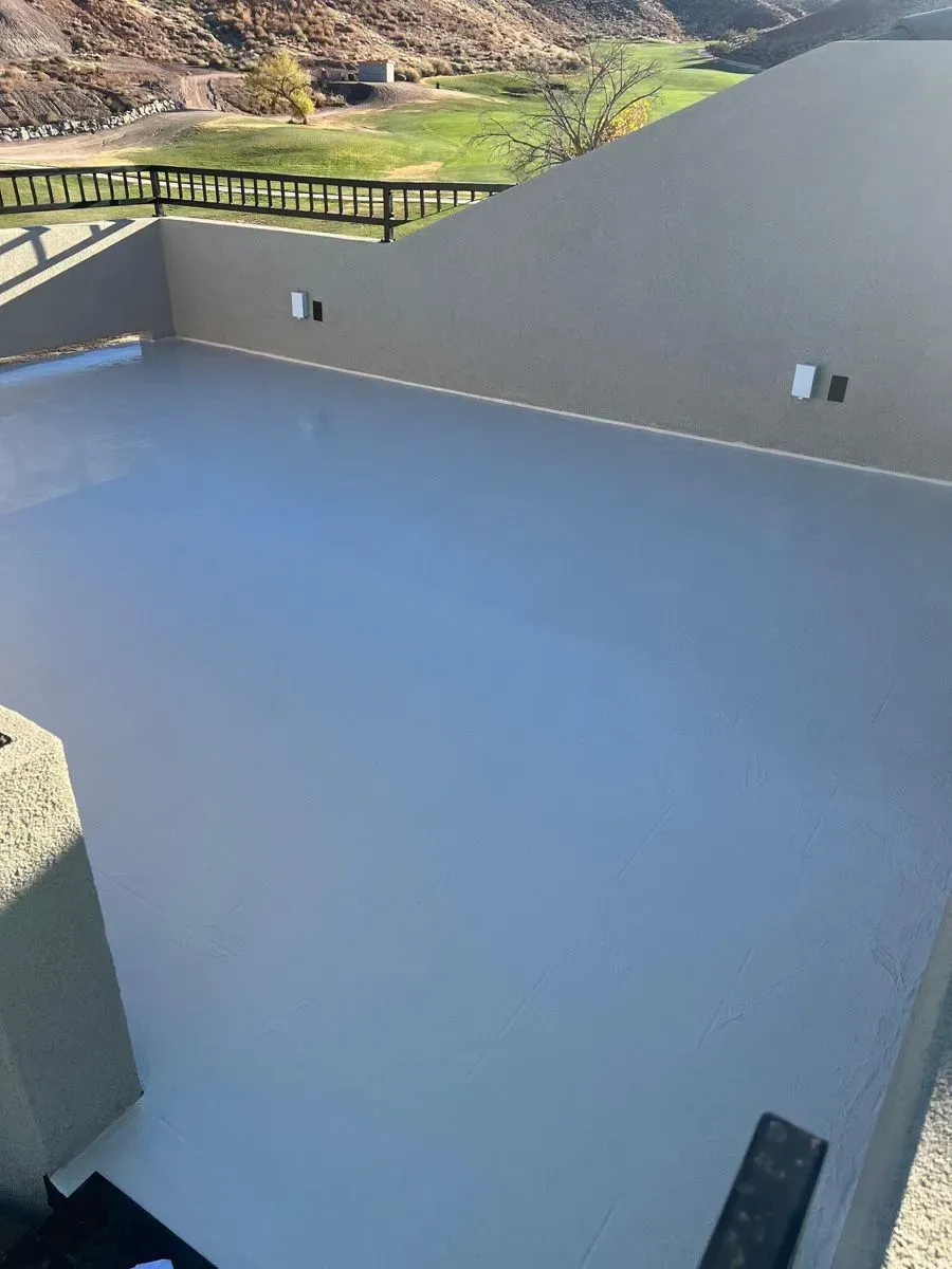 Light grey painted deck with low walls. Outdoors, sunny.