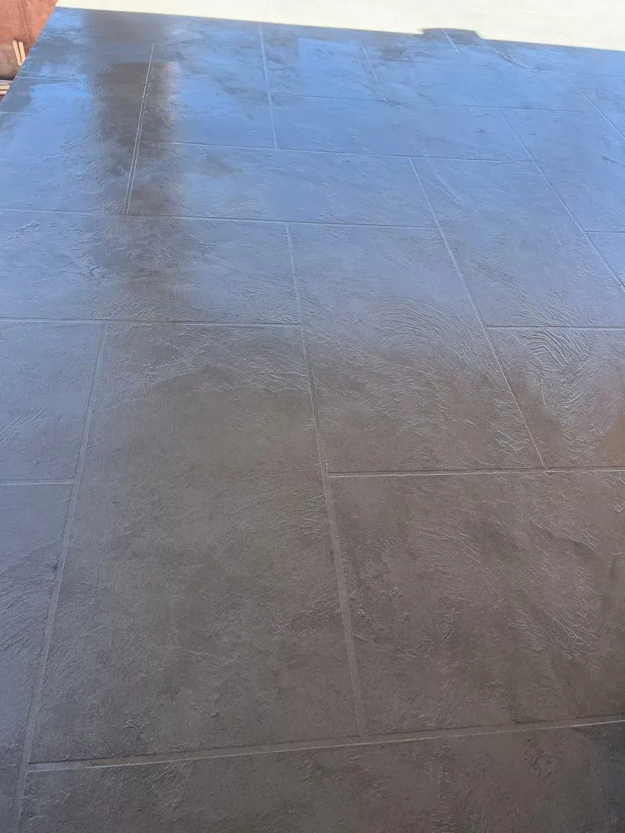 Black tiled floor, wet with some reflection.