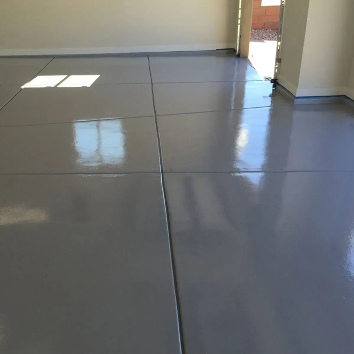 Shiny, gray painted concrete garage floor with visible seams.