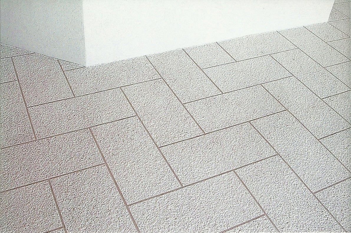Gray tiled floor with visible grout lines, angled view.