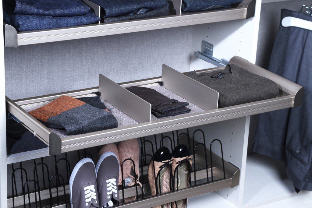 A closet with a shoe rack filled with shoes and slippers
