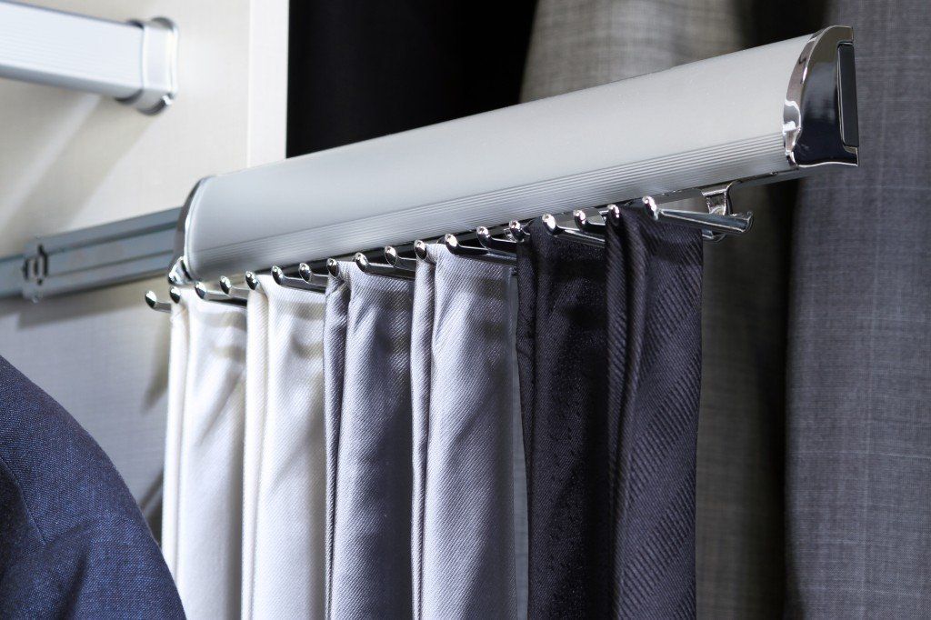 A row of curtains hanging on a rail in a closet