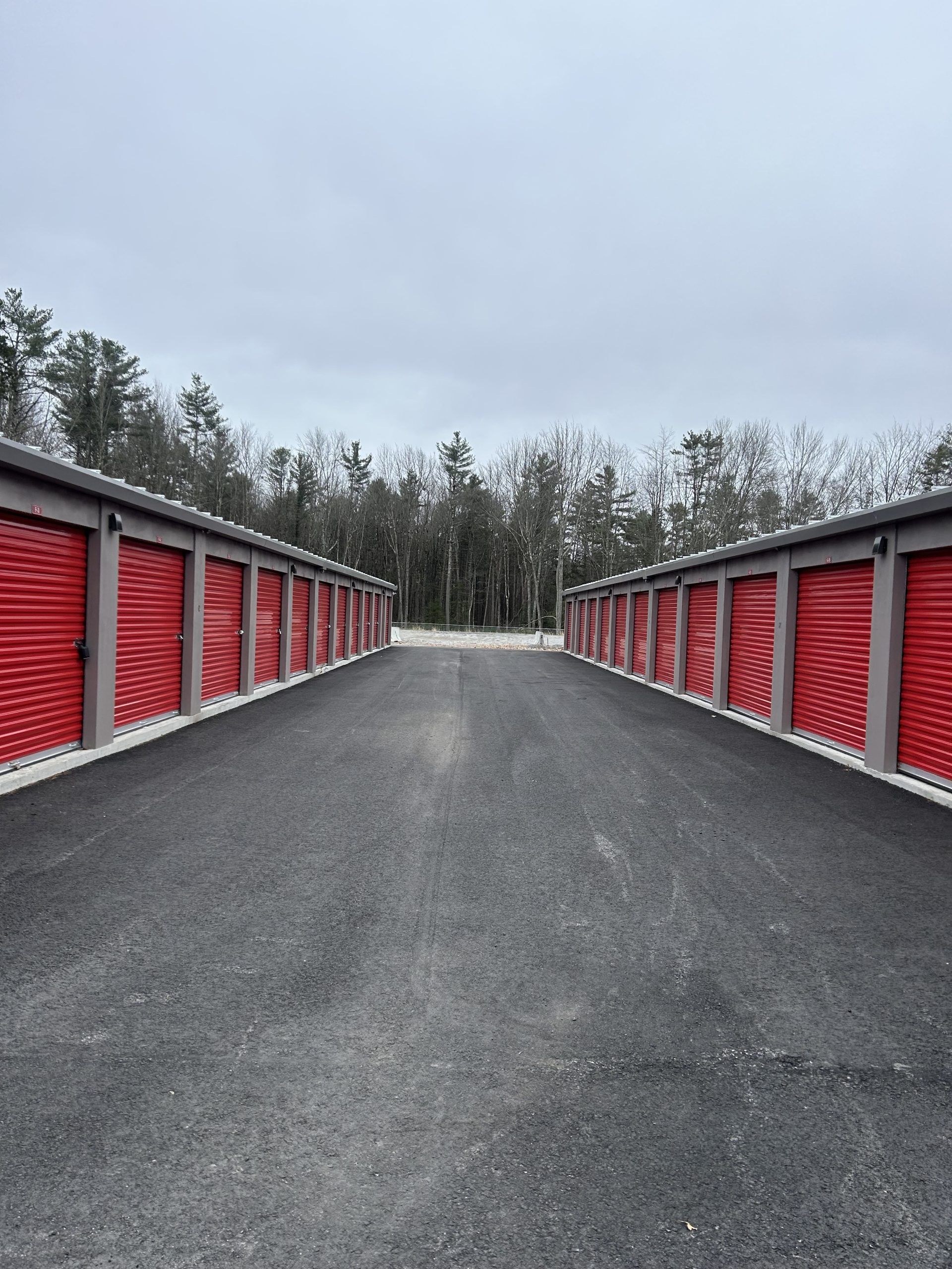 A row of red storage units on the side of a road.