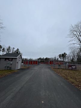 A road leading to a storage facility on a cloudy day.