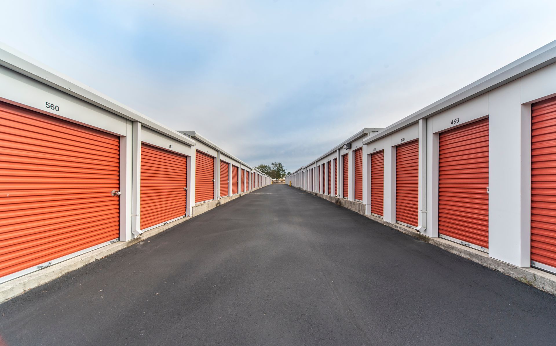 A row of red and white storage units on the side of a road.