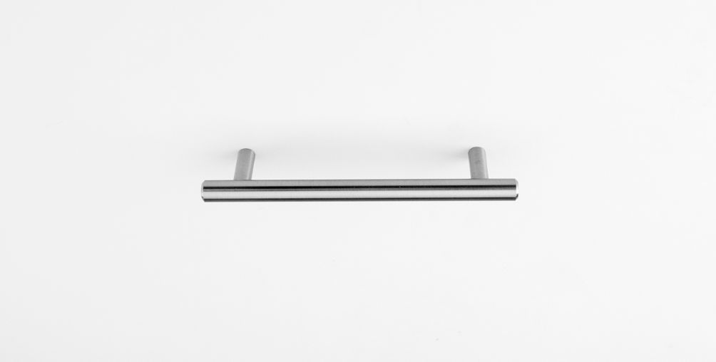 A stainless steel handle is sitting on a white surface.