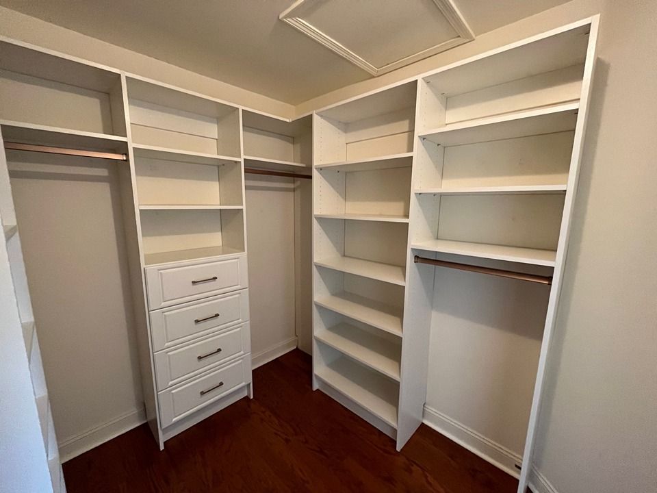 A walk in closet with lots of shelves and drawers.