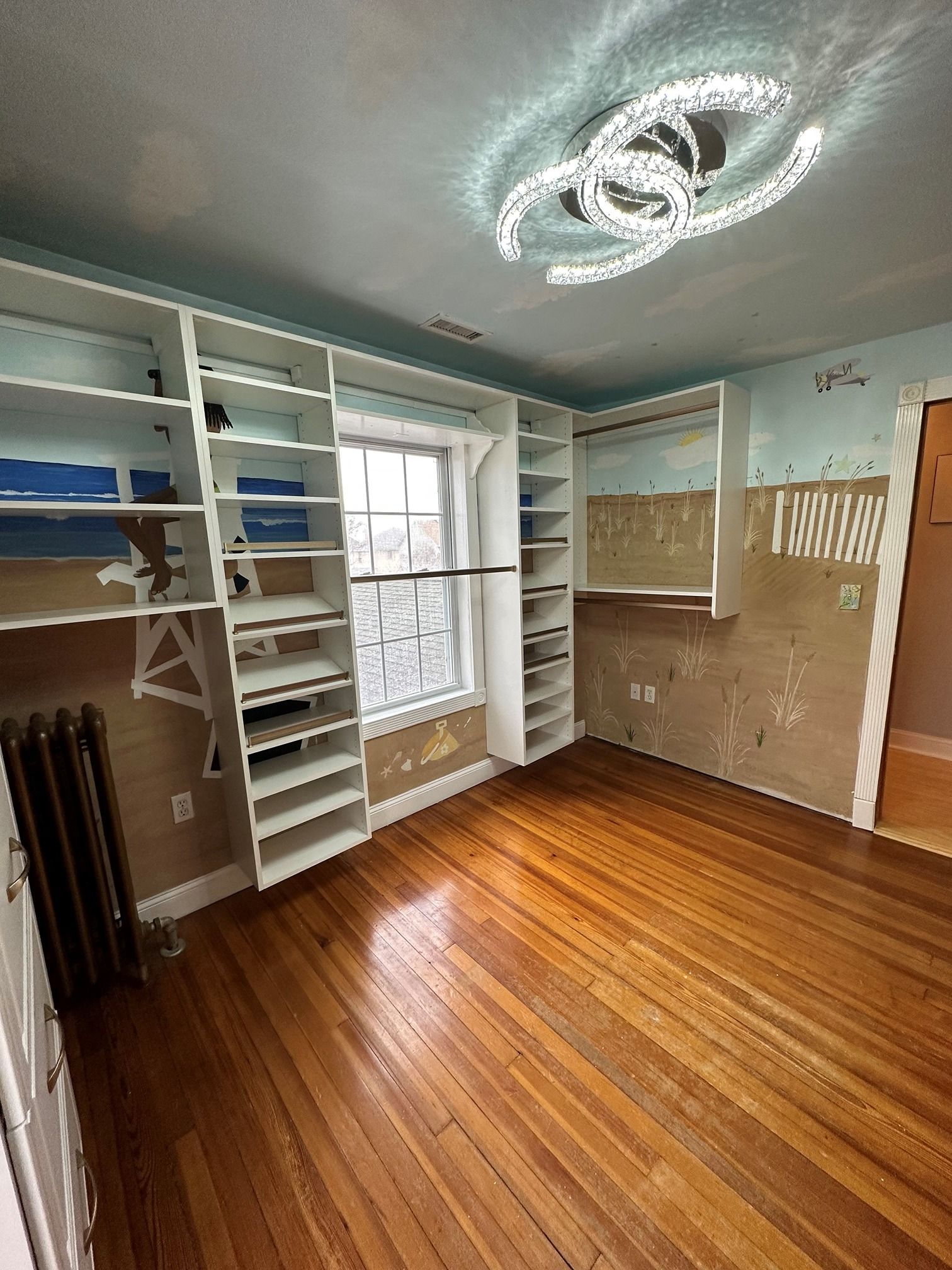 A large closet with lots of shelves and a window.
