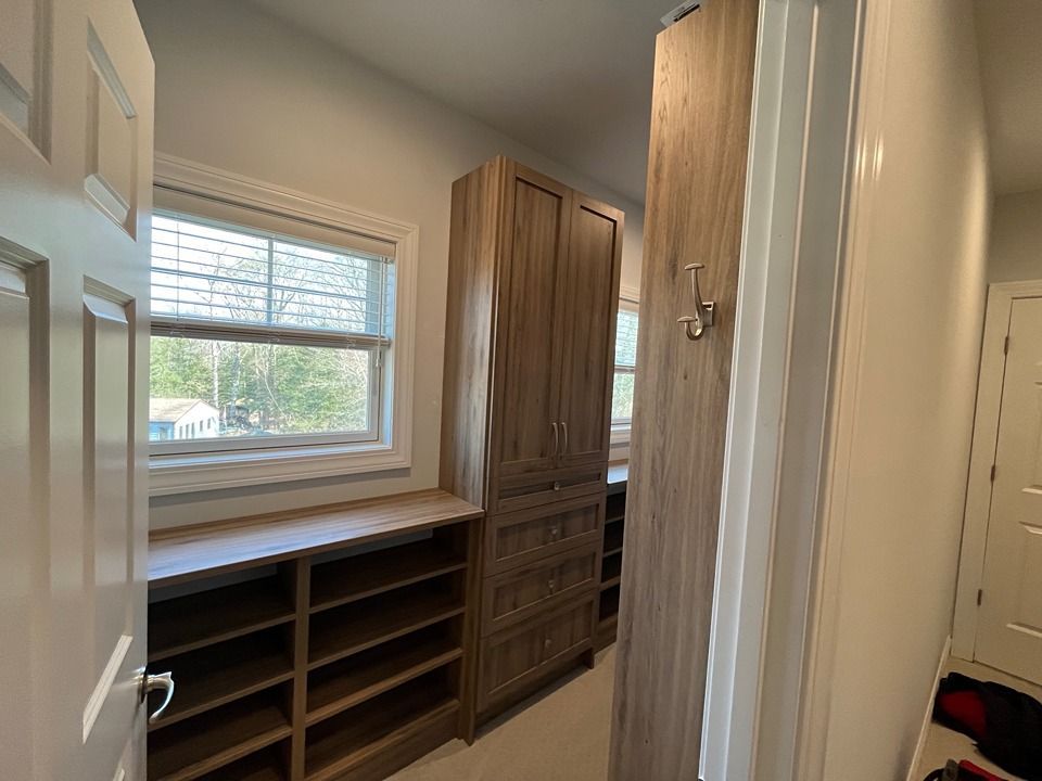 A walk in closet with lots of shelves and a window.