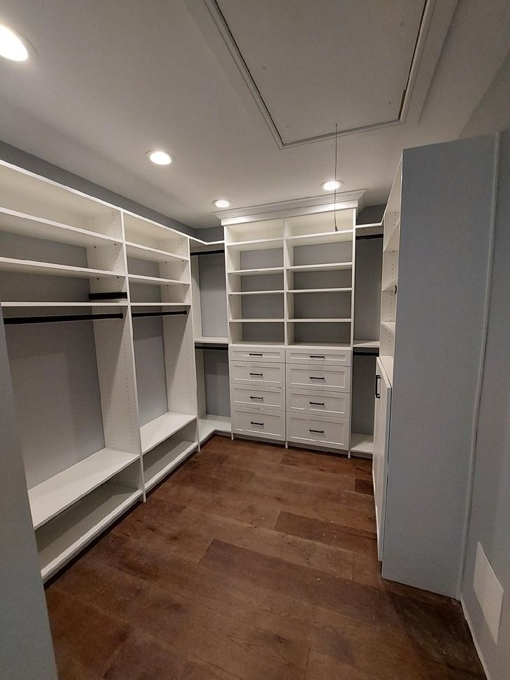 A walk in closet with lots of shelves and drawers.