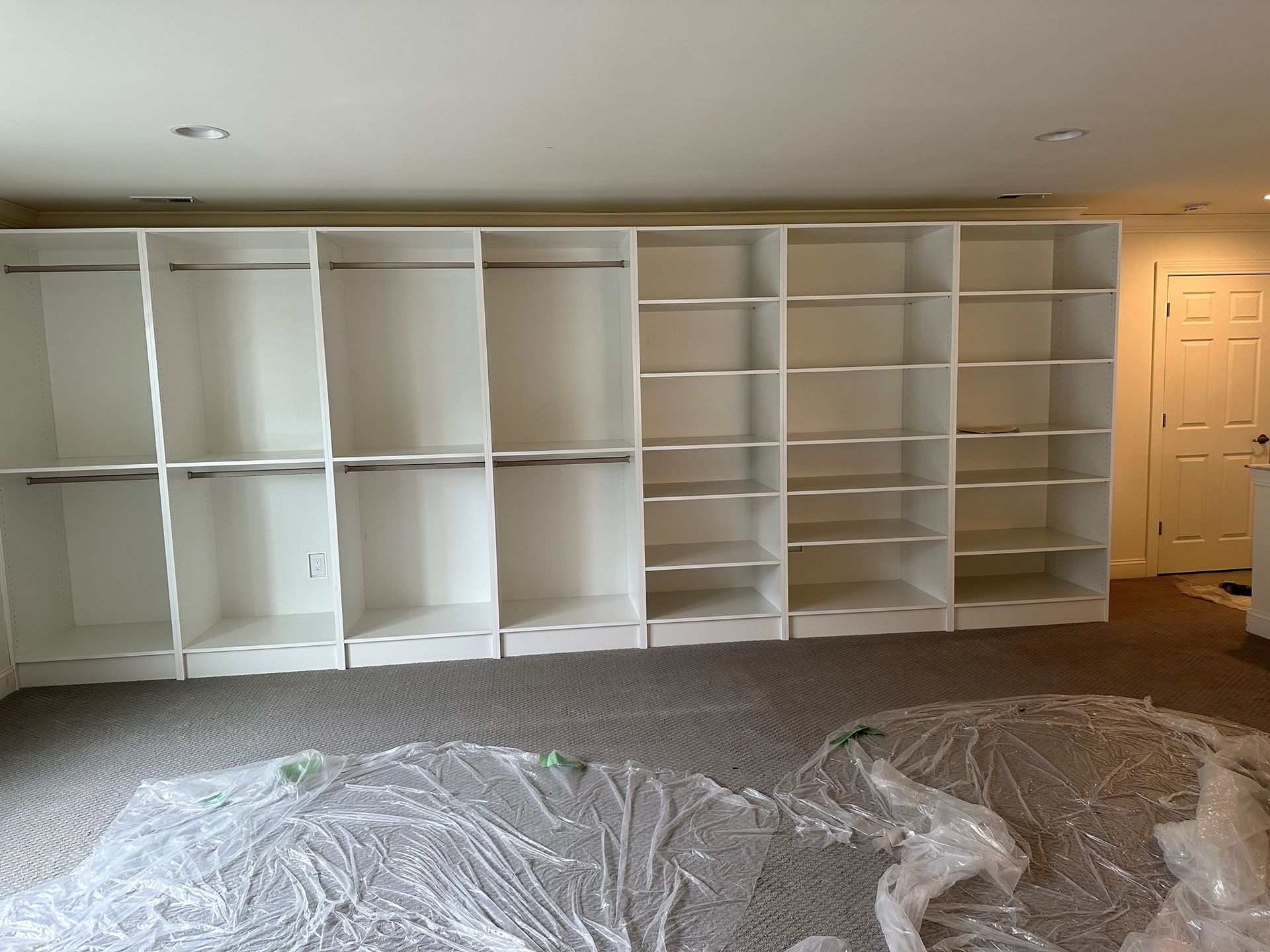 A room with a lot of shelves and a door.