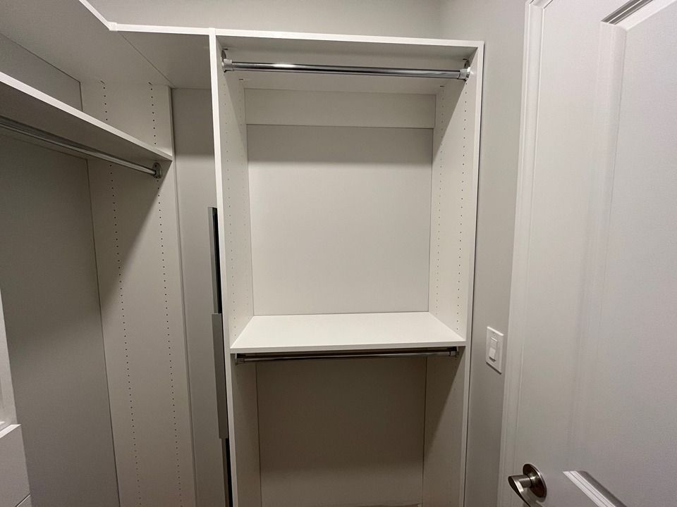 An empty walk in closet with a door and shelves.