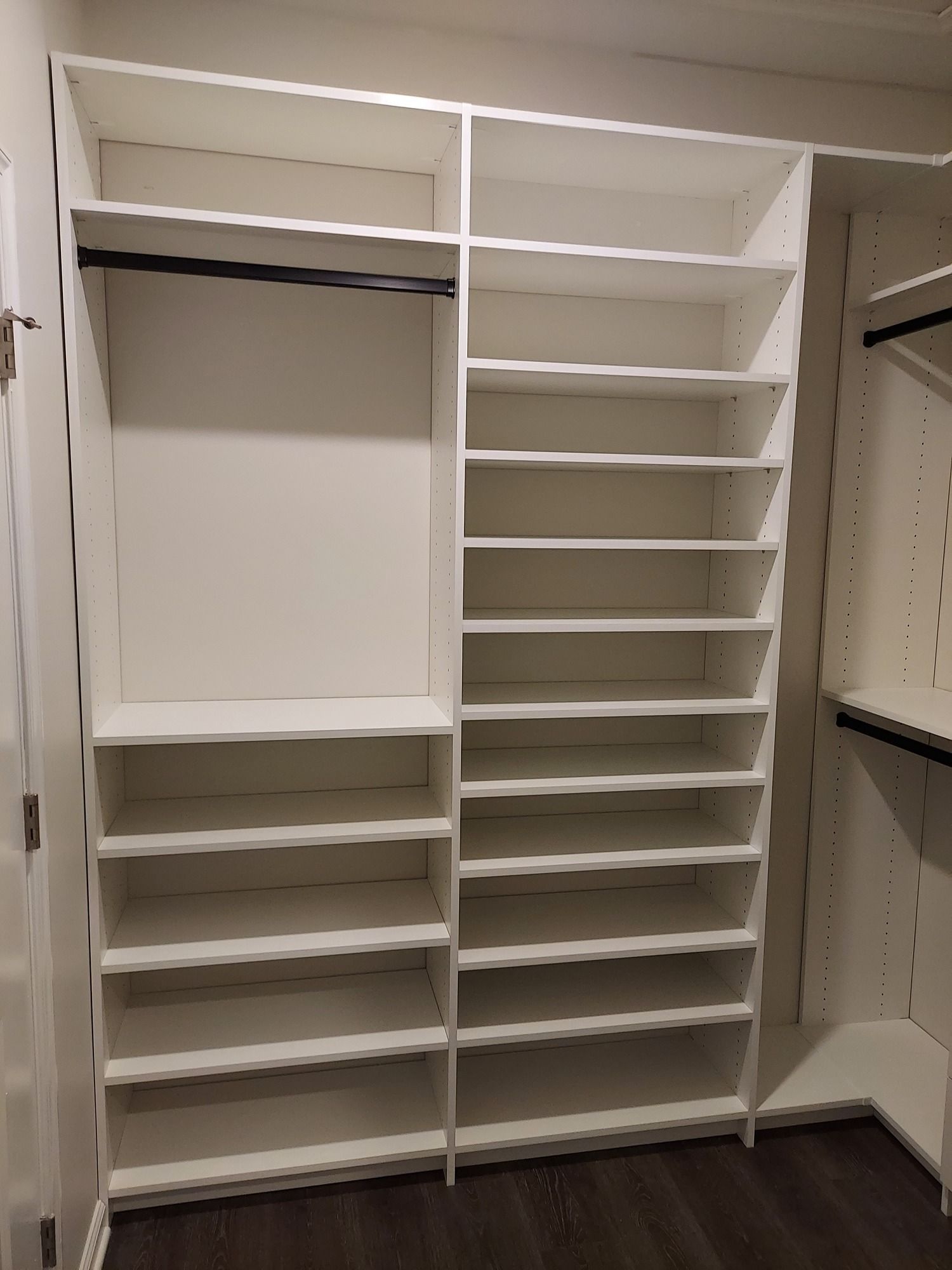 A walk in closet with lots of shelves and hanging clothes.