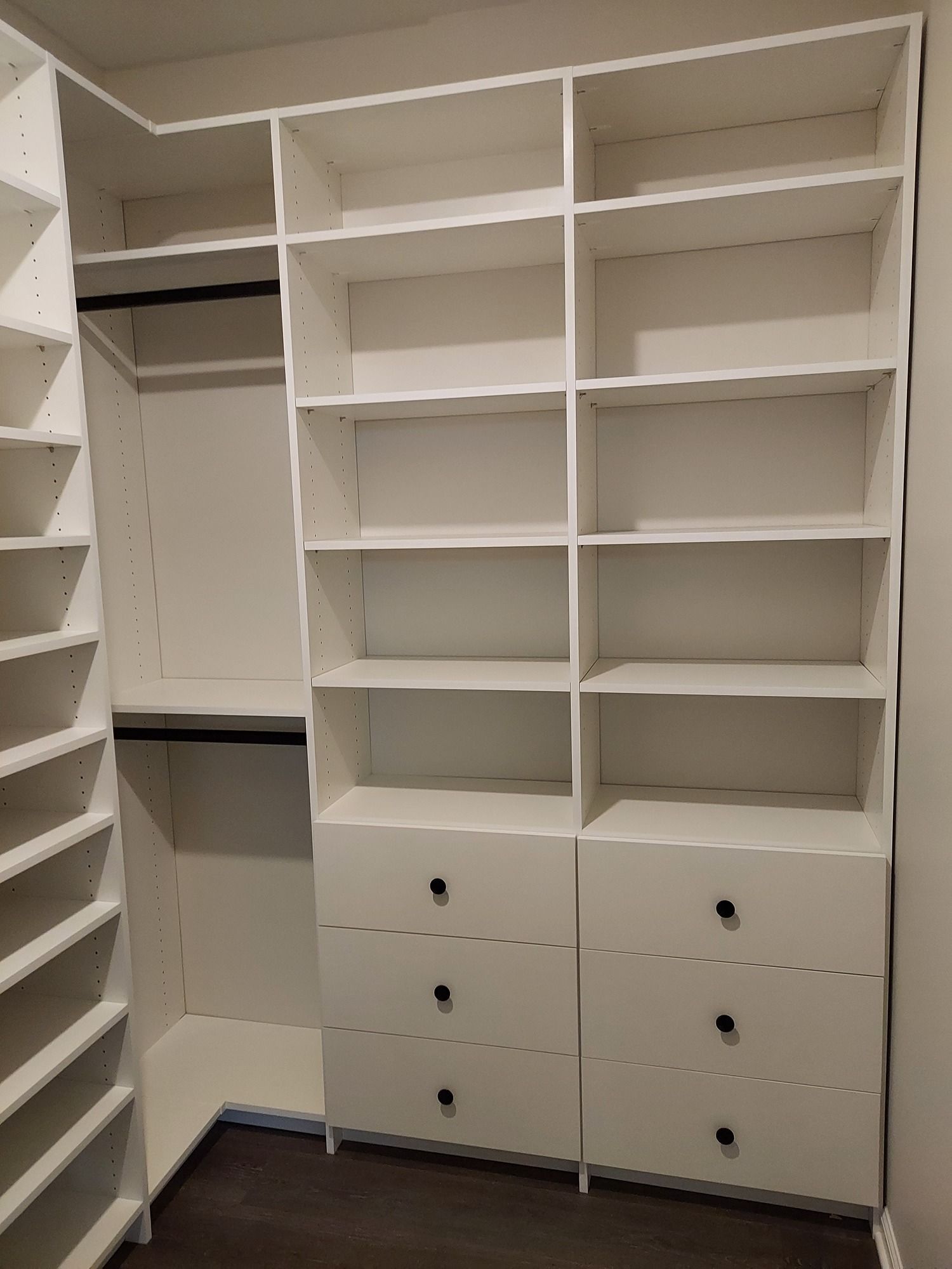 A walk in closet with lots of shelves and drawers.