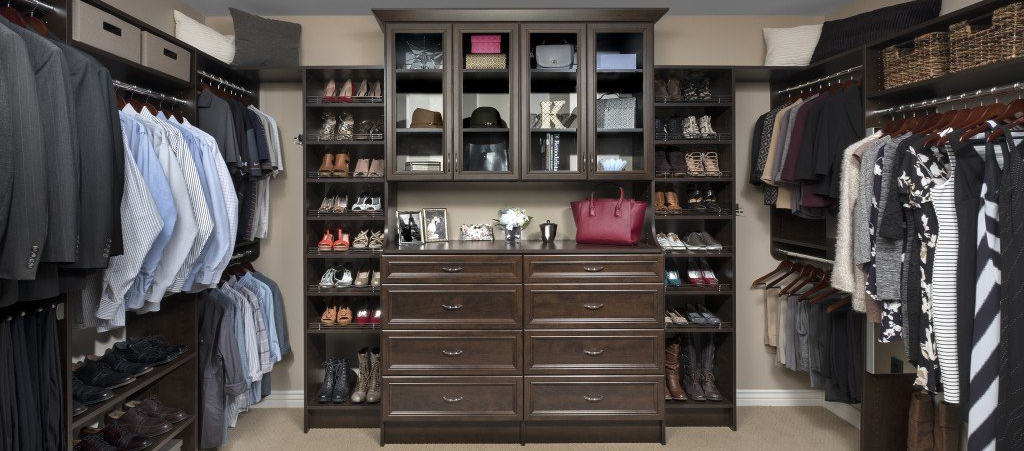A walk in closet filled with lots of clothes and shoes.