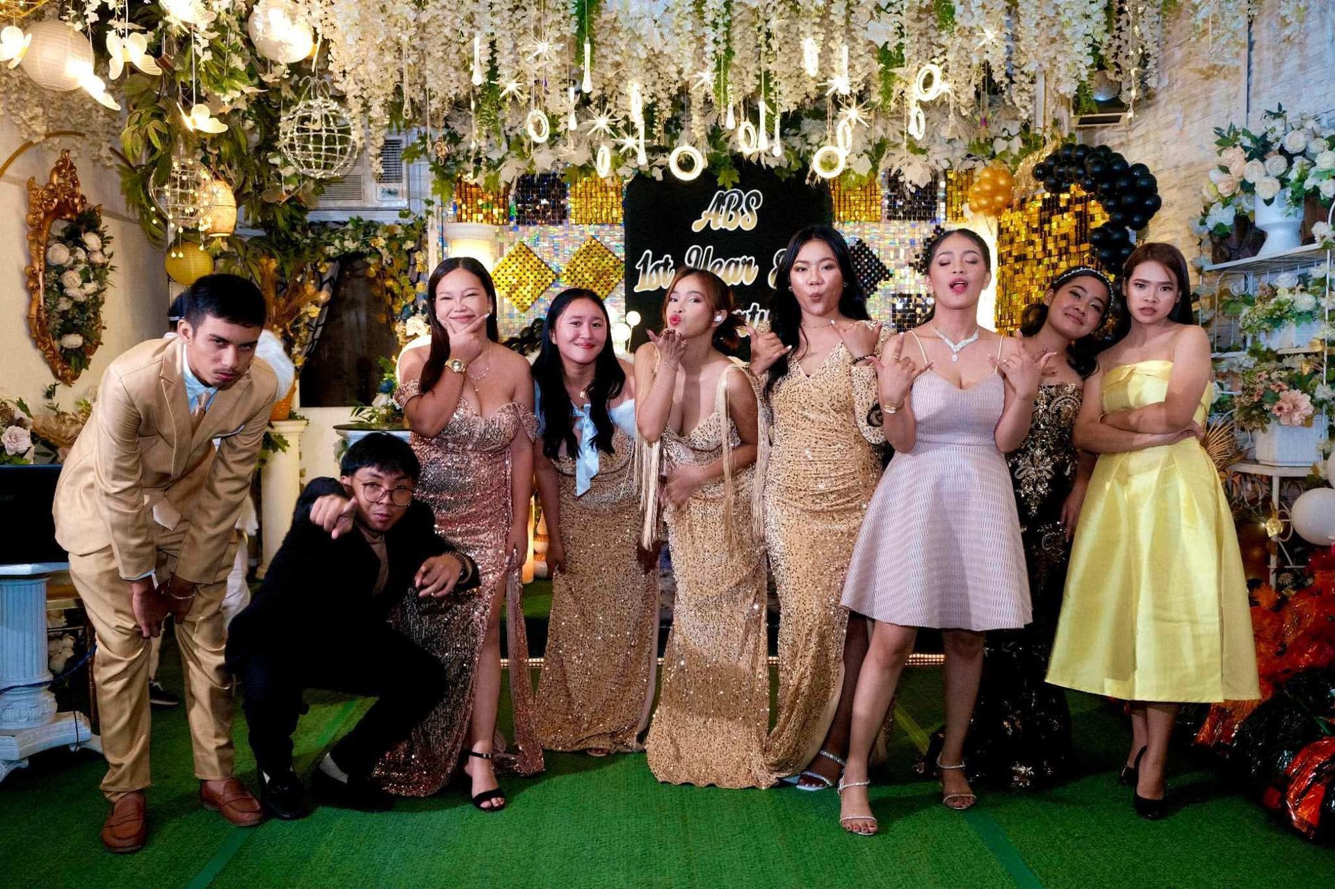 Group of people posing for a photo. Decorated room, people in formal wear with excited expressions.