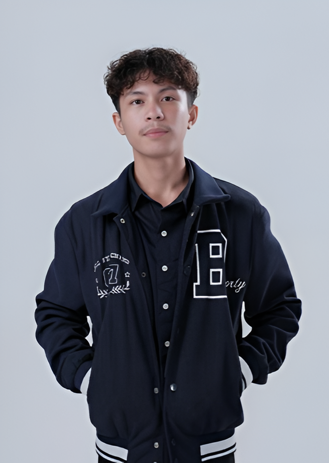 Man wearing a navy bomber jacket with white accents, standing in front of a white backdrop.