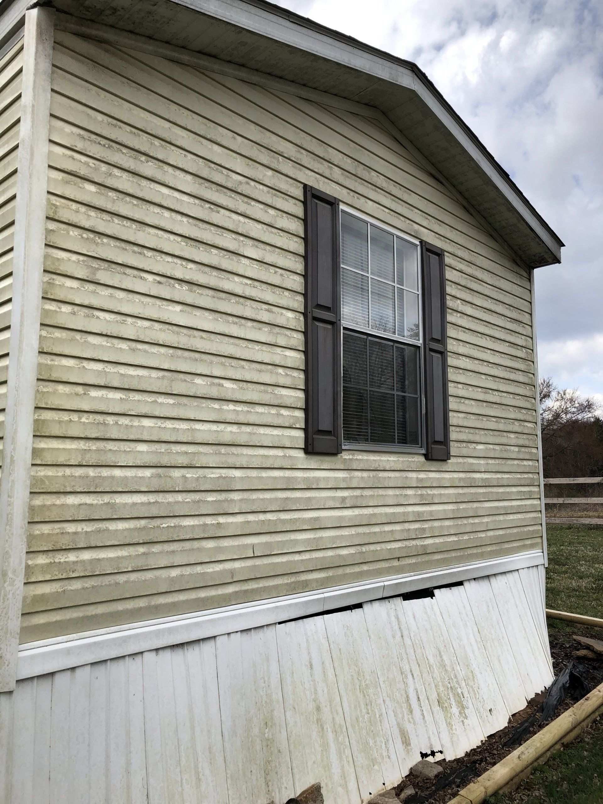 dirty light brown exterior house with one window with 12 divisions