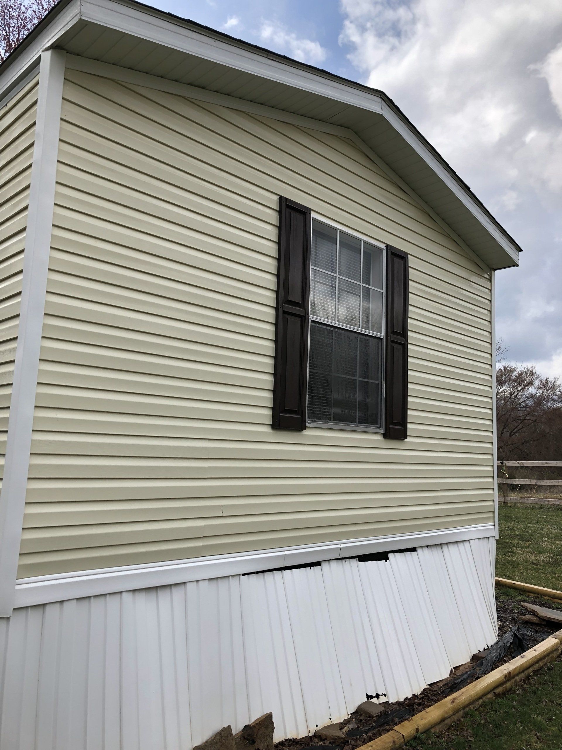 cleaned light brown exterior house with one window with 12 divisions