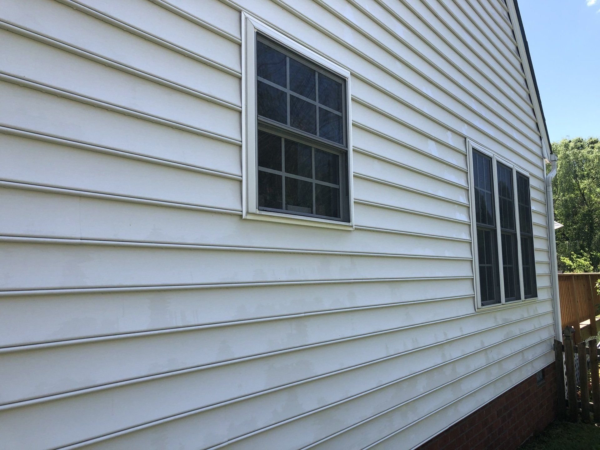 cleaned white house exterior with two windows