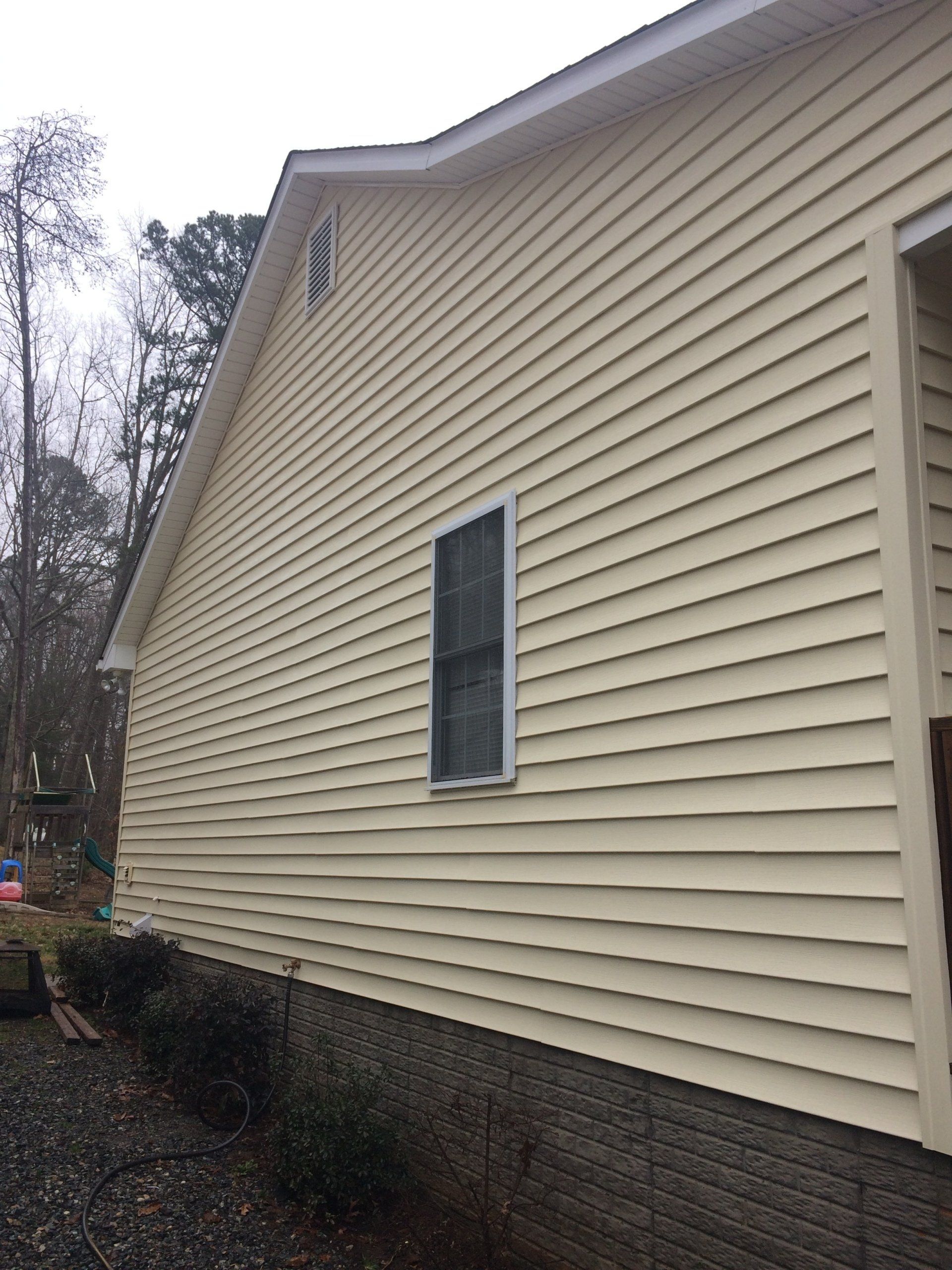 cleaned sand color exterior house with one vertical window