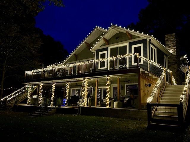 A green house with Christmas lights on it is lit up at night