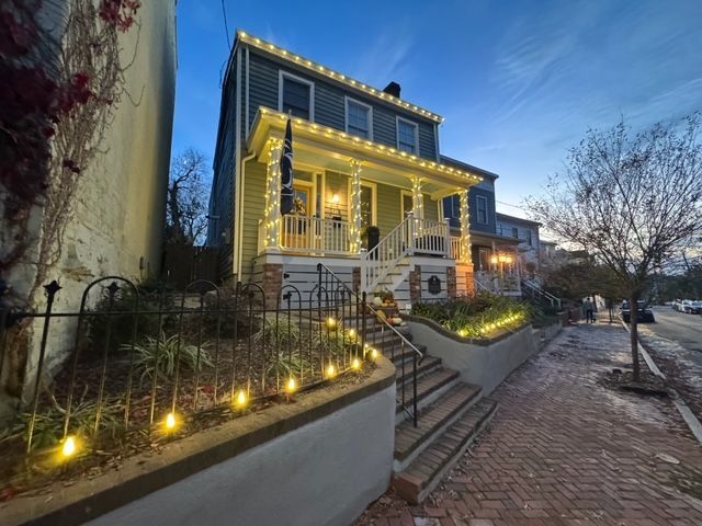 A house with Christmas lights on the porch and stairs