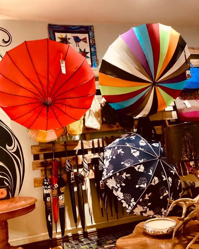 Shop display of colorful umbrellas, parasols, and patterned umbrellas hanging indoors