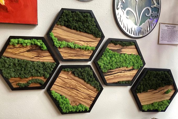 Hexagonal wall art with layered wood and green moss-like accents, arranged in a cluster.