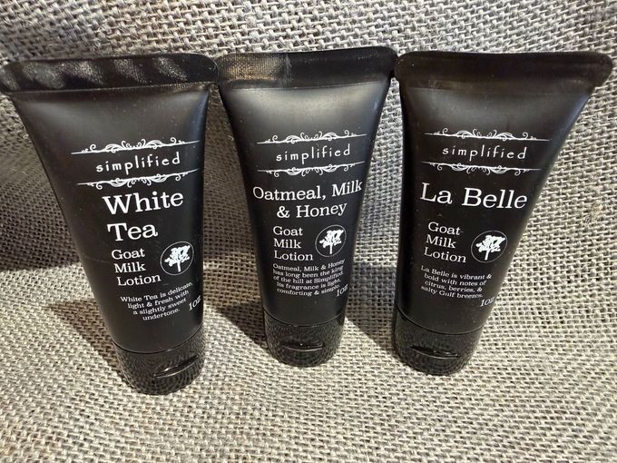 Three black cosmetic tubes labeled White Tea, Caramel Milk & Honey, and La Belle on fabric.