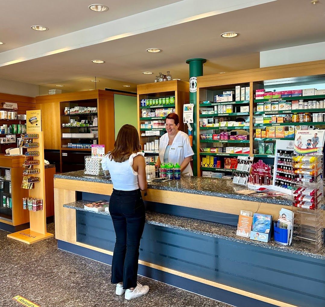 Eine Frau steht an einem Tresen in einer Apotheke.