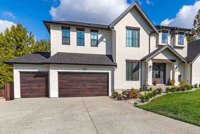 Scenic view of a house with a well-maintained front and attractive garage door