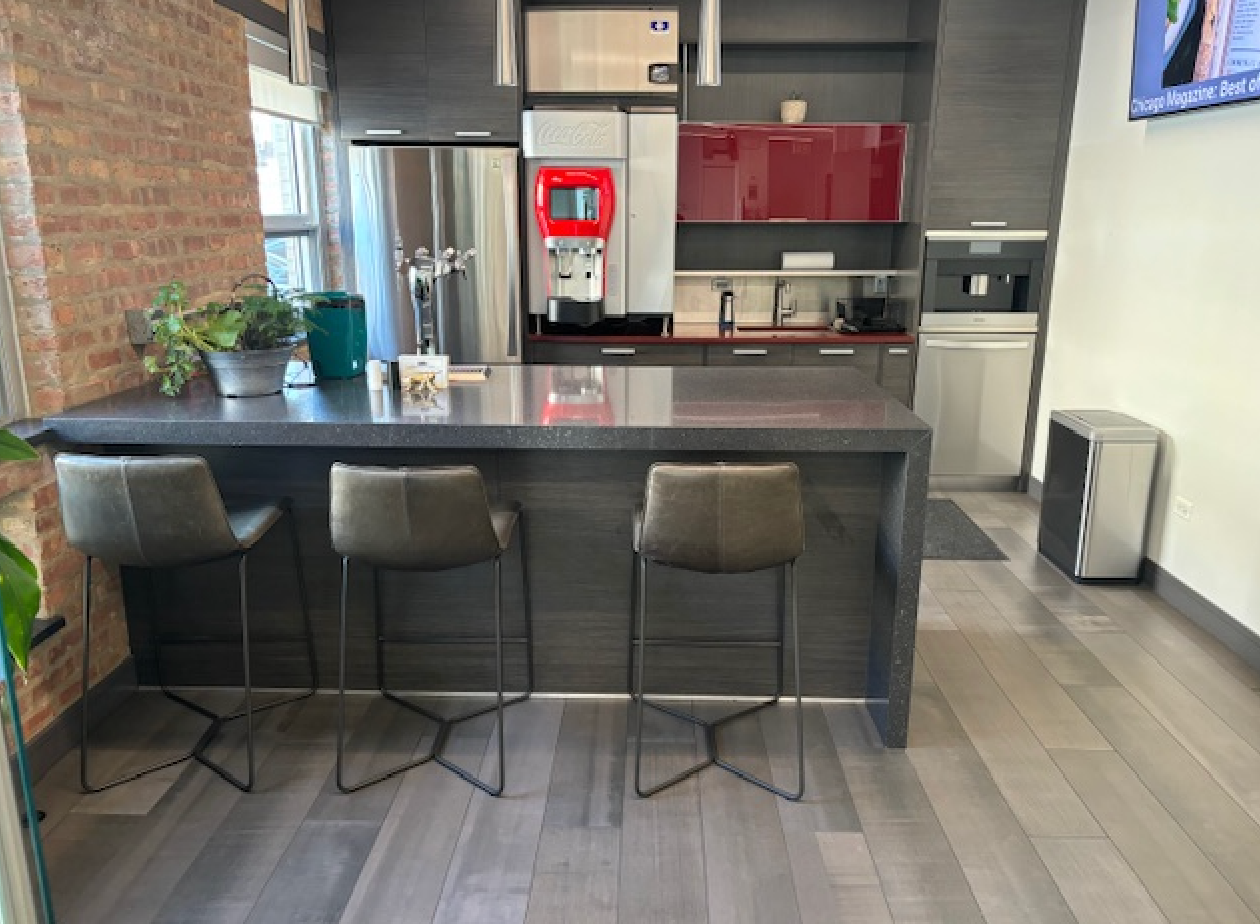 A kitchen with a large island and three stools.