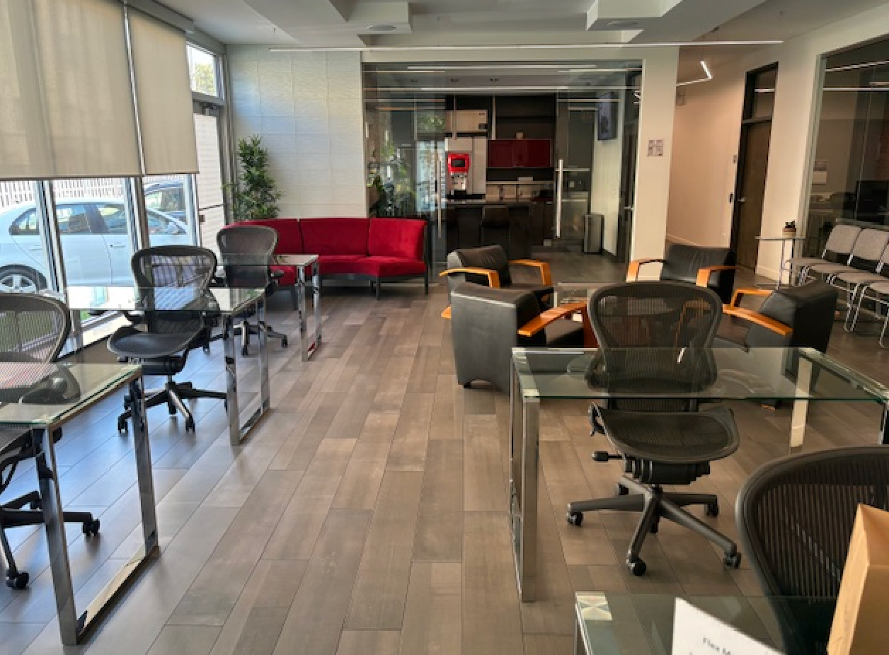 There are many chairs and tables in the room.