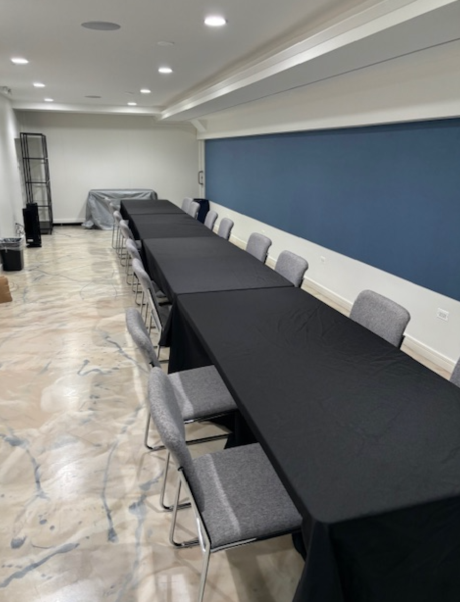 A room with a long table and chairs in it