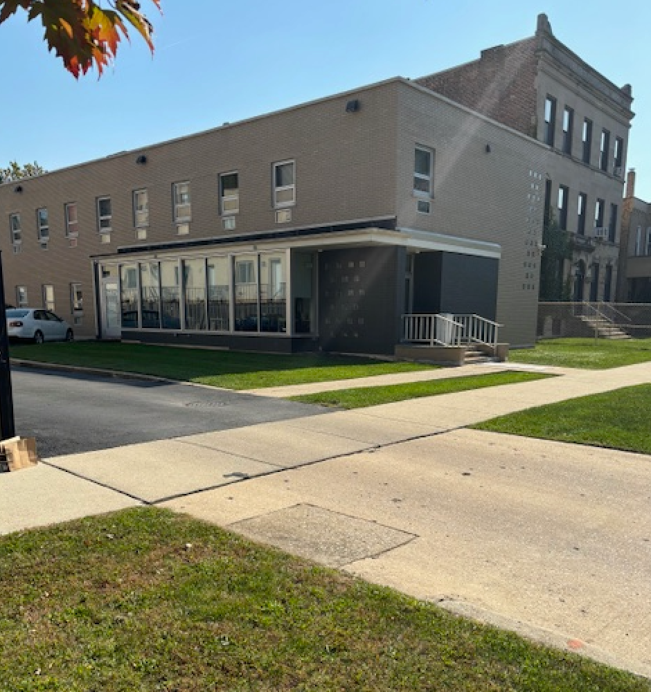 A large building with a lot of windows and a sidewalk in front of it